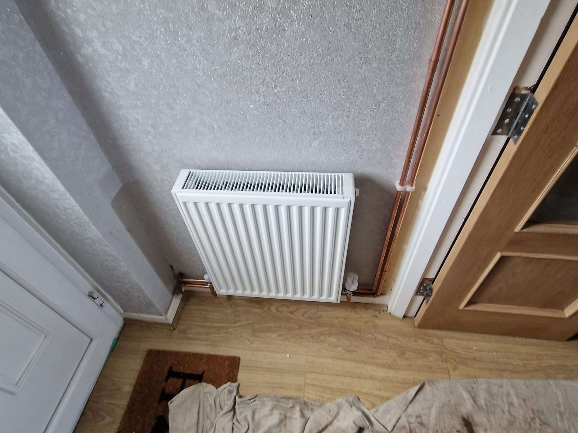 White radiator on wooden floor
